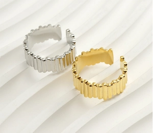 Detailed view of pleated texture on adjustable gold and silver stainless steel rings