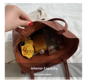 Detail view of large brown tote bag interior with umbrella and cosmetic bottles