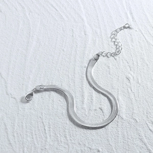 Close-up of silver snake chain bracelet with lobster clasp and adjustable metal extender