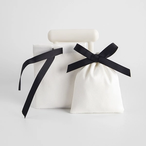 White velvet jewelry pouch with black ribbon drawstring and envelope design