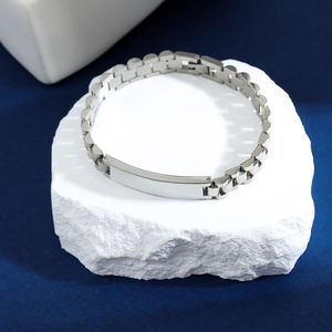 Macro shot of silver stainless steel watch-style bracelet with blank metal plate detail
