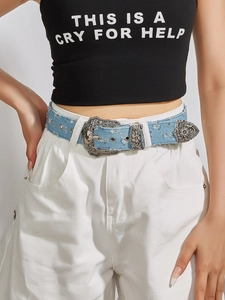 Detail of a vintage denim belt styled with a black crop top and white trousers on a model