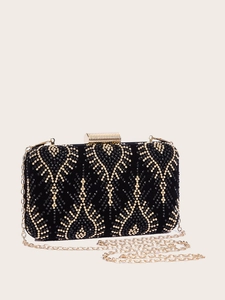 Detail of elegant black clutch featuring gold metal clasp and sparkling diamond patterns