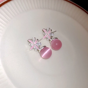 Macro di orecchini a fiore in argento con zirconi e una pietra rosa occhio di gatto tonda