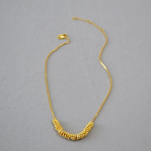 Dettaglio della collana in ottone placcato oro con zirconi brillanti e catena a box