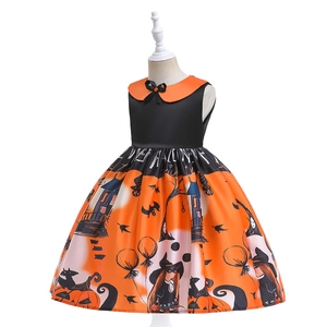 Close-up of sleeveless Halloween girl dress featuring pumpkin and witch prints on orange fabric