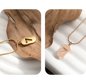 Macro detail of number 7 pendant necklaces in gold and rose gold on a snake chain