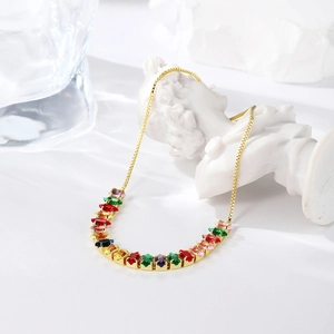 Detailed close-up of a gold-plated necklace featuring vibrant multi-colored gemstones