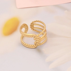 Detailed close-up of a hollow gold band ring with bead edges and a central knot design