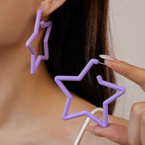 Boucles d'oreilles étoiles en acrylique violet mat avec tiges argent portées par un mannequin
