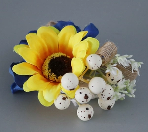 Details von Sonnenblume und blauer Stoffblume mit rustikalem Juteseil und weißen Beeren-Deko