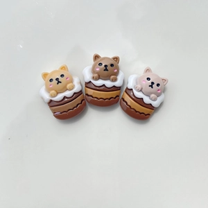 Close-up of three resin cartoon animal charms in puppy and bear chocolate dessert shapes