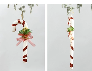 Detail of red and white 30cm Christmas candy cane with pine needles and red ribbon bow