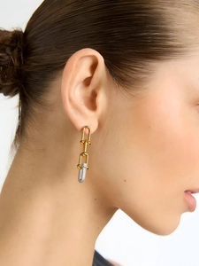 Close-up of 18K gold U-shaped link earrings with pavé diamonds on model's ear