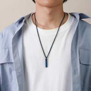 Male model wearing a navy blue rectangular tungsten pendant on a woven wax cord necklace