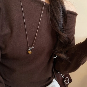 Detail view of tiger eye stone pendant on brown braided rope with silver T-buckle closure