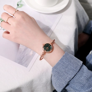 Rose gold cuff watch with green starry sky dial shown on a woman wrist for daily wear