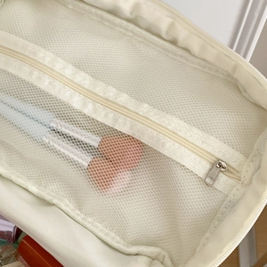 Detail view of the interior mesh pocket with zipper for organizing makeup brushes