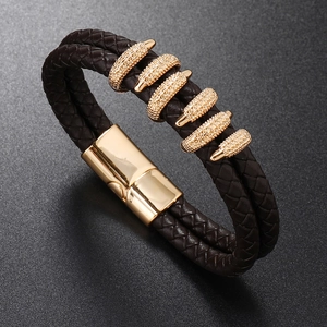 Close-up of brown braided leather bracelet with golden textured metal clasp and magnetic closure