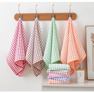 Detailed view of checkered cotton tea towels hanging in pink, brown, and blue colors