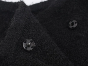 Gros plan sur le tissu noir en mélange de laine avec double fermeture à boutons pression