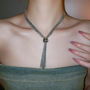 Collana multifilo argentata con ciondolo a sfera e nappe indossata sul collo