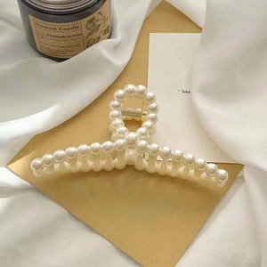 Elegant large pearl claw clip for women in Korean INS style on white silk background