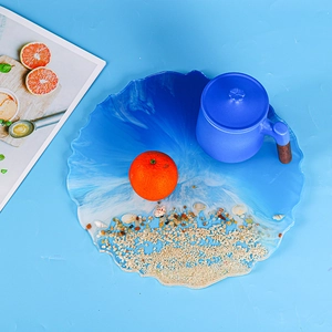 Ocean theme resin tray with blue waves and real sand seashells on blue background