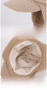 Detail of warm winter knit hat showing thick beige yarn and soft white fleece lining