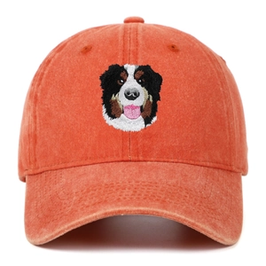 Close-up of Bernese Mountain Dog embroidery on an orange washed canvas baseball cap