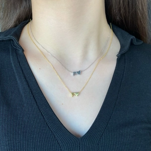 Close-up of double-layer S925 silver necklaces with letter F and heart-shaped pendants
