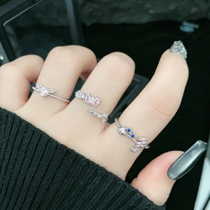 Close-up of three layered silver rings with pink butterfly and heart-shaped zircon details