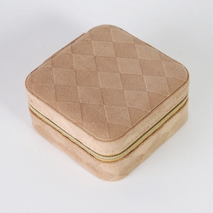 Close-up of quilted velvet jewelry box in camel with a premium gold zipper detail