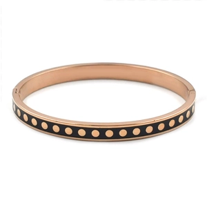 Détail du bracelet en acier inoxydable or rose avec émail noir et motifs à pois dorés