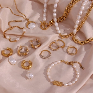 Detailed view of golden pearl jewelry set with 11:11 engraving on soft pink silk fabric