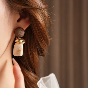 Close-up of vintage geometric earrings with wood resin and interlocking gold metal rings