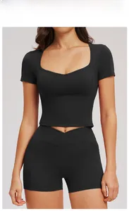 Close-up of tight-fitting black yoga top featuring a square neckline and V-shaped hemline