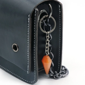 Conical orange crystal stone keychain on black leather bag with silver metal chain link