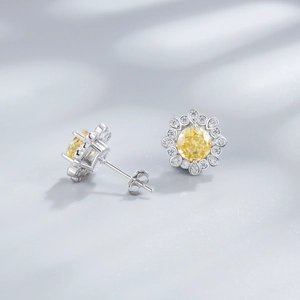 Silver flower stud earrings with a round yellow stone and sparkling clear petals