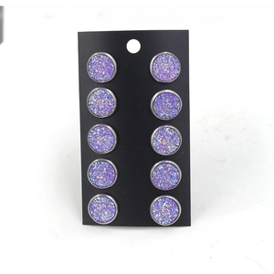 Détail de cinq paires de boucles d'oreilles 12mm en acier titane violet étoilé sur carte