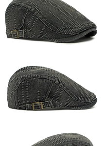 Detail view of washed black denim beret with white stitching and vintage metal buckle