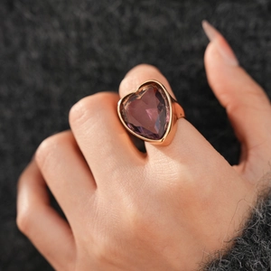 Detail of a large purple heart-shaped zircon gemstone set in a gold bezel cocktail ring