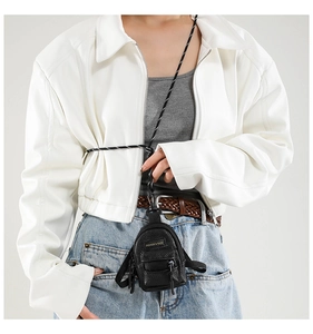 Close-up of mini black leather bag pendant with fashion strap and metal clasp detail