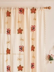 Detailansicht der Weihnachtsstickerei mit Weihnachtssternen und Glocken auf Spitze