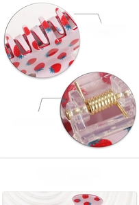 Detailed macro view of strawberry pattern hair claw clip with strong golden metal spring
