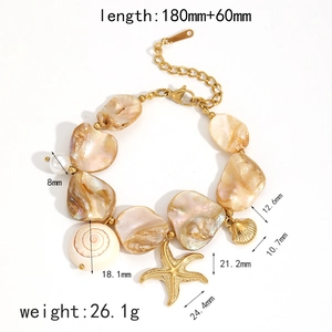 Gold stainless steel bracelet with starfish and seashell charms, pearls on white background