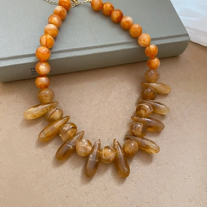 Detail view of Bohemian amber-style resin beaded necklace with drop-shaped pendants