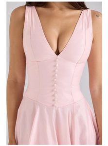 Close-up of pink V-neck sleeveless dress featuring silk texture and front decorative buttons
