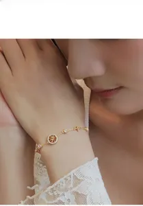Detail of gold star compass bracelet with zircon pavé setting on lace sleeve background