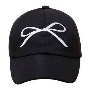 Detailed front view of a kids black baseball cap with white embroidered bow detail
